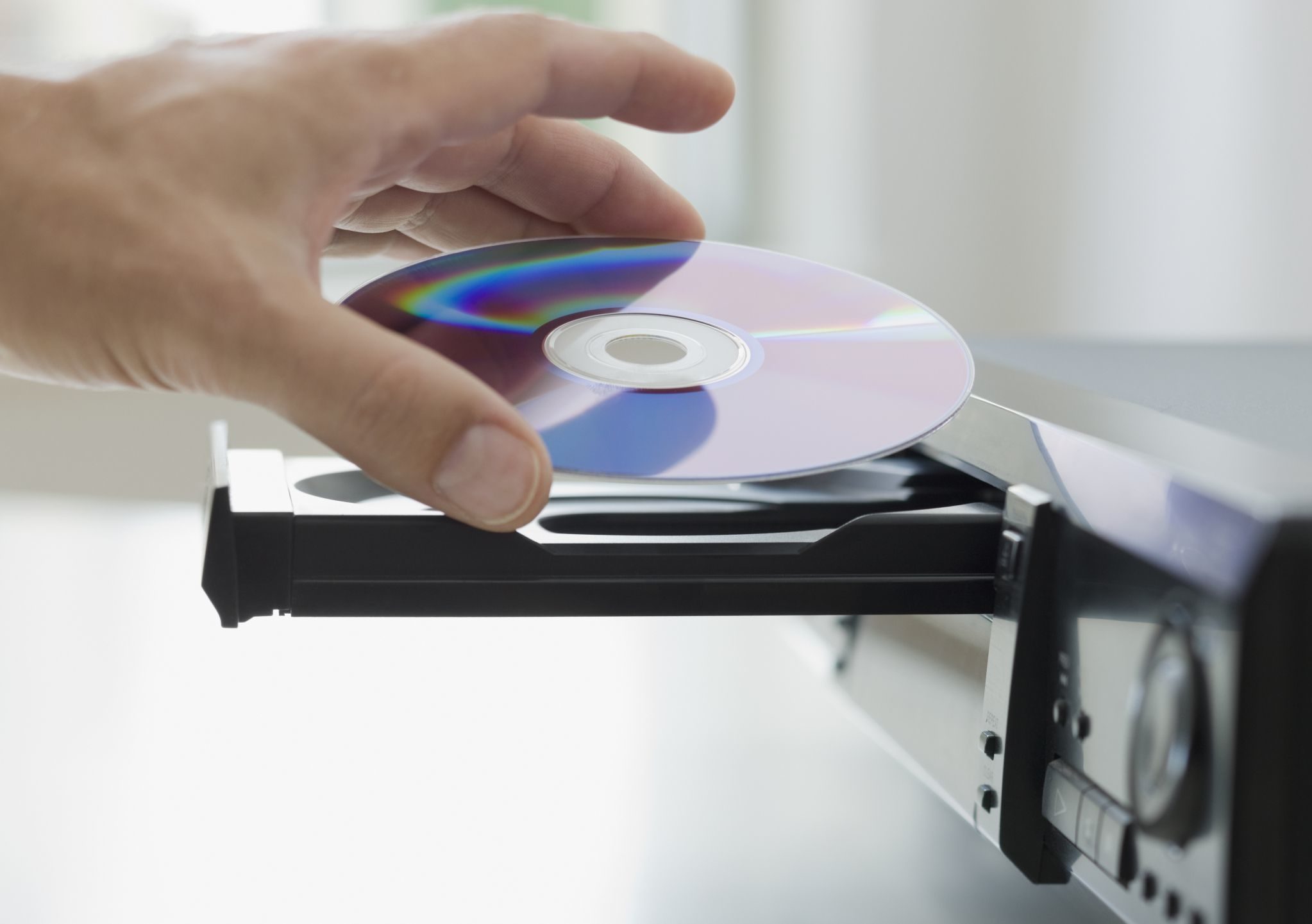 Business man placing cd in machine cd tray. Judicial Research Duplication & Replication Services are quick, easy, and affordable for CD, DVD, Blu-Ray, Video, Tape. Trusted for over 23 years, best in duplication services